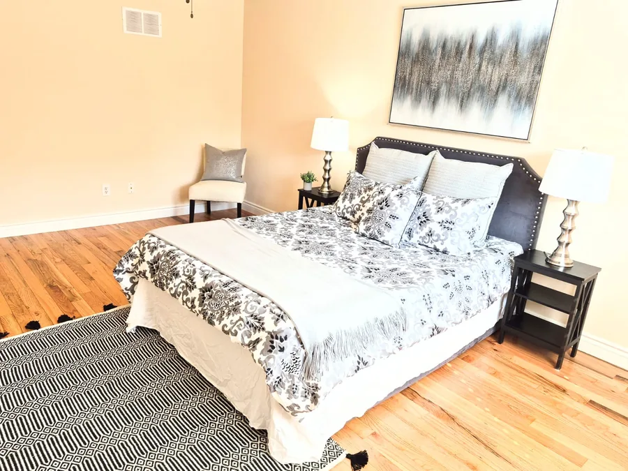 Neutral bedroom staged with layered black, white, and grey textiles