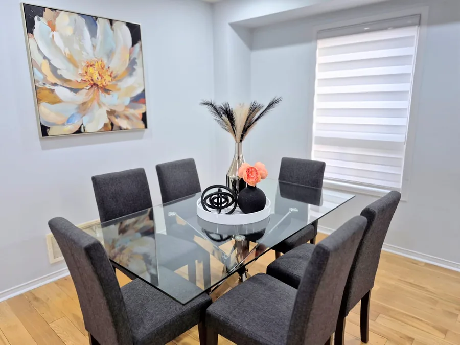 Contemporary dining room with a glass table and floral artwork