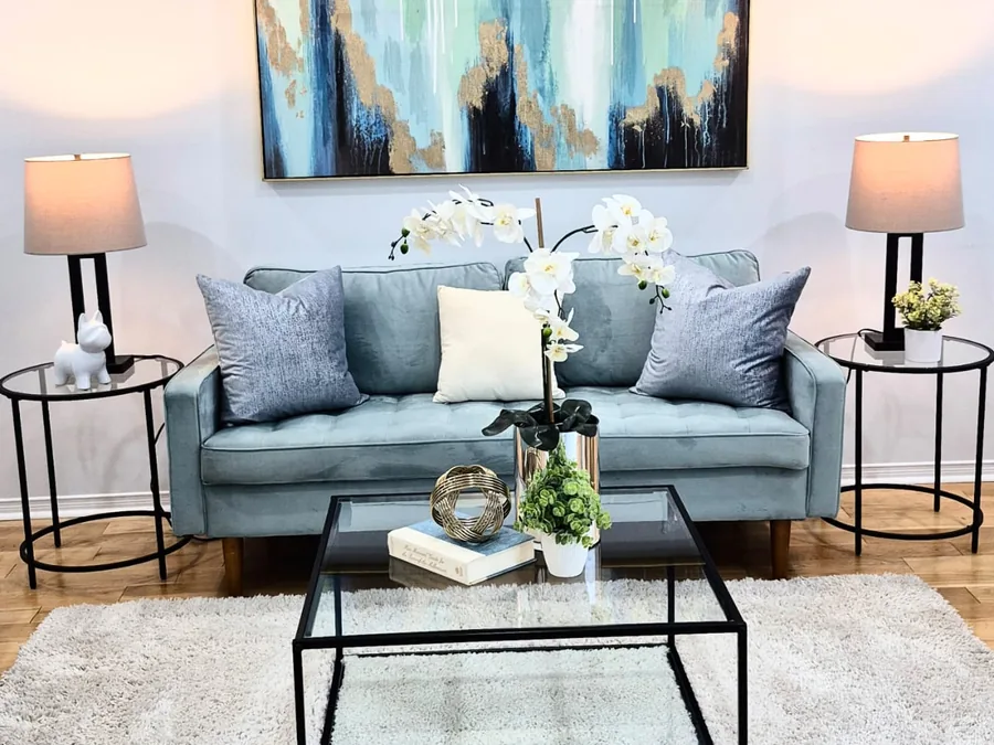 Symmetrical blue living room styling with an orchid centrepiece